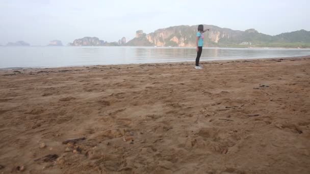 Menina apontando na praia — Vídeo de Stock