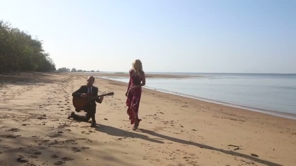 Meisje en gitarist op strand — Stockvideo