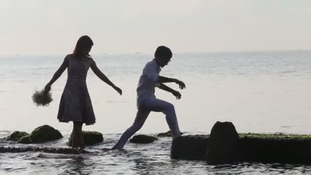 Man en vrouw lopen op strand — Stockvideo