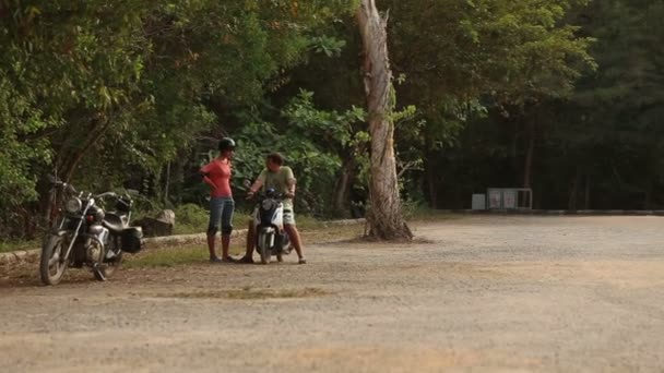 Инструктор учит девушку водить скутер — стоковое видео