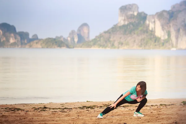 Chica haciendo gimnasia en la playa al amanecer — Foto de Stock