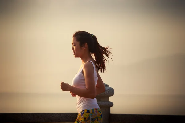 Asian girl running at sunrise — Stock Photo, Image