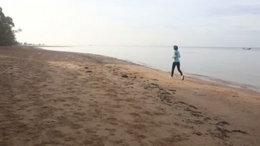 kum plajı üzerinde koşan kız