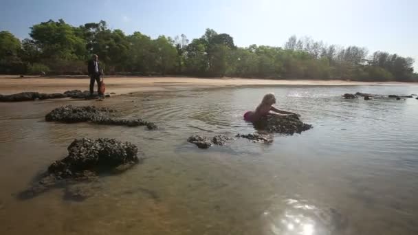 Meisje en man gitaarspelen op zee — Stockvideo