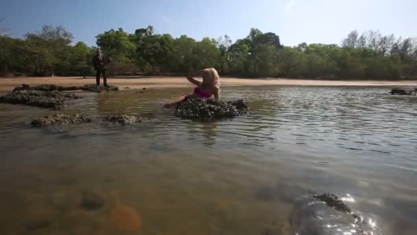 Ragazza e uomo che suonano la chitarra in mare — Video Stock