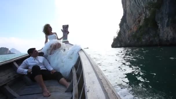 Bride and groom sitting in boat — Stock Video