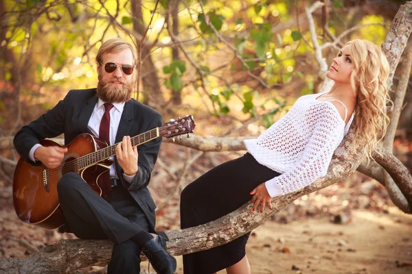 Tyttö ja mies kitara rannalla — kuvapankkivalokuva