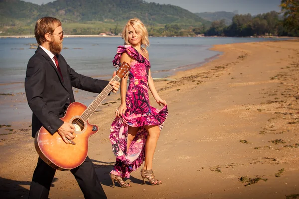 Girl and man with guitar on beach — Stock Photo, Image