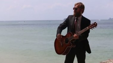 Adam denizde gitar çalmak