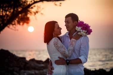 Gelin ve damat kumsalda sarılma