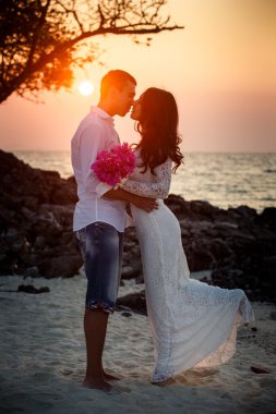Gelin ve damat kumsalda sarılma