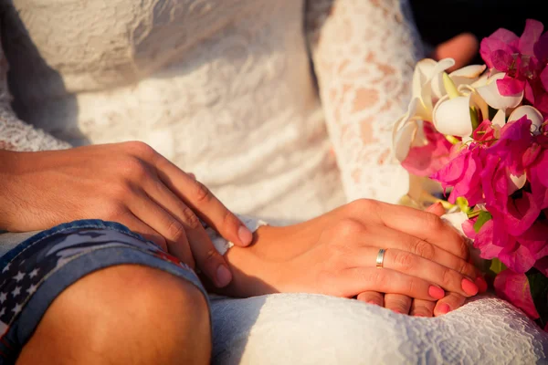 Braut und Bräutigam Hände mit Blumenstrauß — Stockfoto