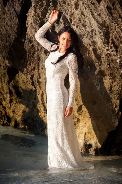 Brunette mariée à grande falaise dans l'eau — Photo