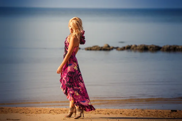 Mulher em roxo dresson praia — Fotografia de Stock