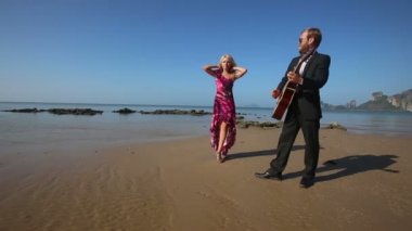 Kadın ve adam sahilde gitar ile
