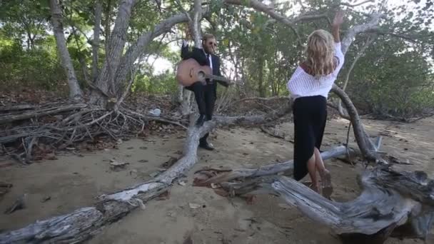 Жінка і чоловік з гітарою на пляжі — стокове відео