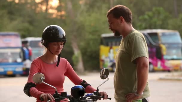 Инструктор преподает девушке вождение скутера — стоковое видео