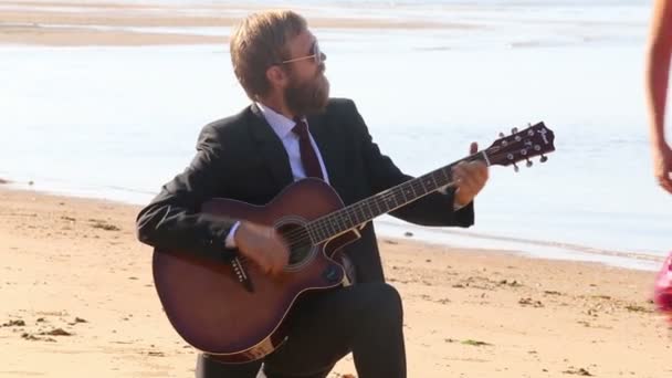 Menina e homem com guitarra na praia — Vídeo de Stock