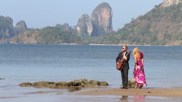 Mädchen und Mann mit Gitarre am Strand — Stockvideo