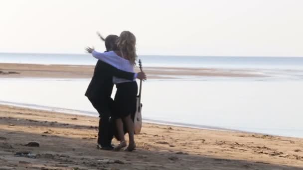 Flickan och mannen med gitarr på stranden — Stockvideo