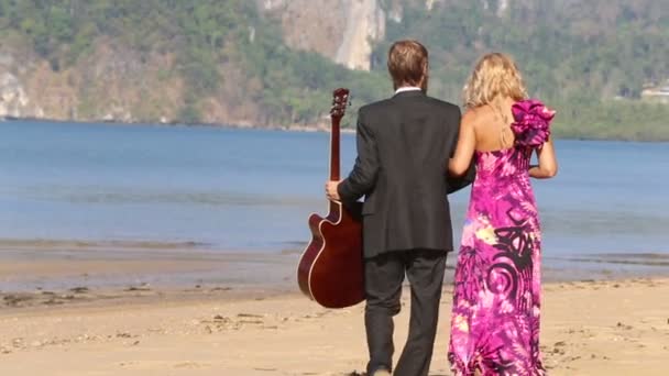 Mujer y hombre con guitarra en la playa — Vídeo de stock