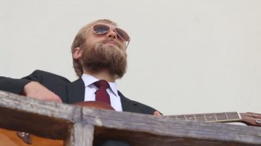takım elbiseli sakallı adam ve gitar ile gözlük