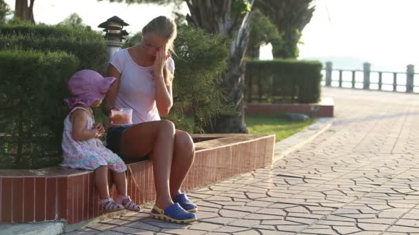 Mutter füttert Tochter im Park mit Früchten — Stockvideo