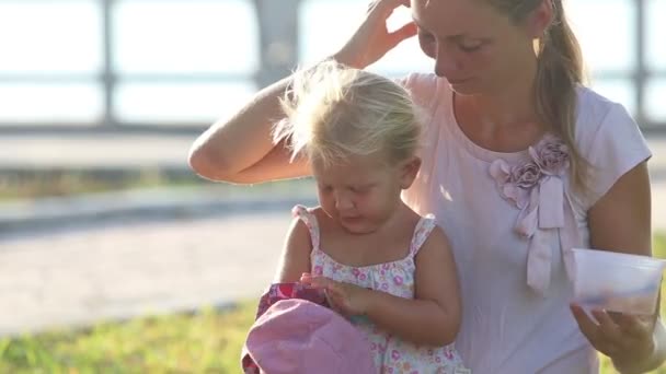Mutter sitzt mit Tochter auf Rasen — Stockvideo