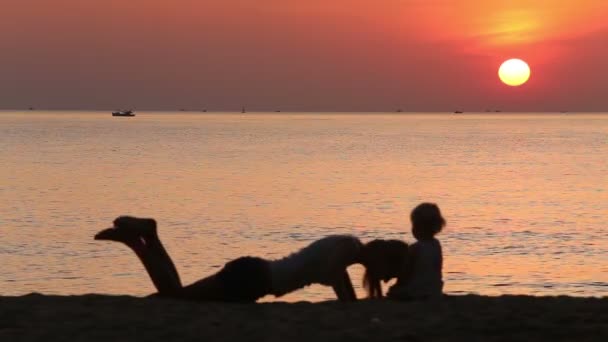 Moeder en peuter doen oefeningen bij zonsopgang — Stockvideo