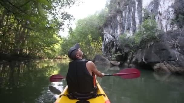 Oude man paddels op kajak in canyon — Stockvideo