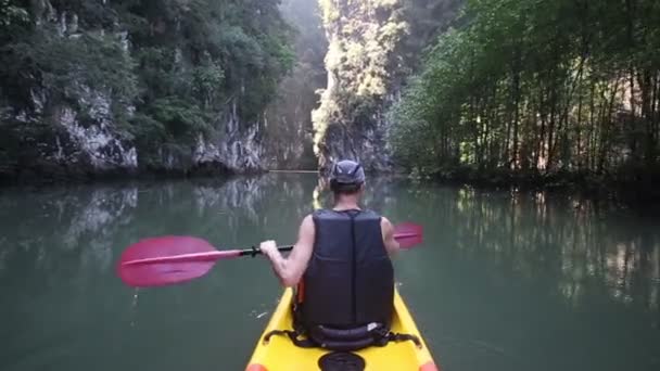 Oude man paddels op kajak in canyon — Stockvideo