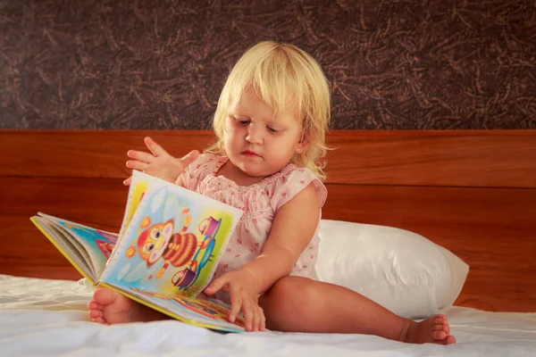 Девочка смотрит на обложку книги — стоковое фото