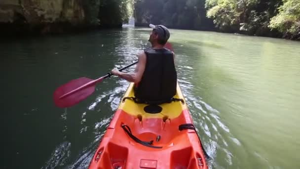 Man achterkant weergave rijen op kajak — Stockvideo