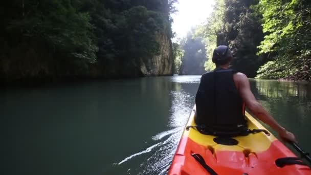 Oude man paddels op kajak in canyon — Stockvideo