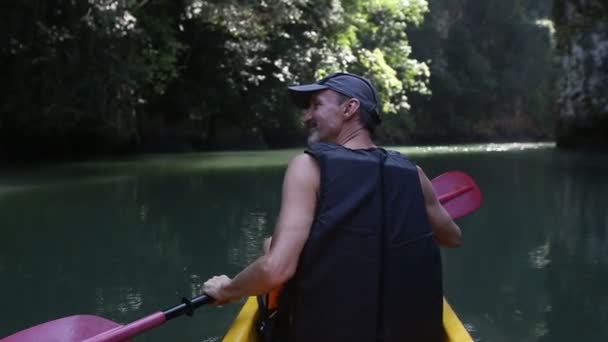 Alter Mann paddelt auf Kajak in Schlucht — Stockvideo