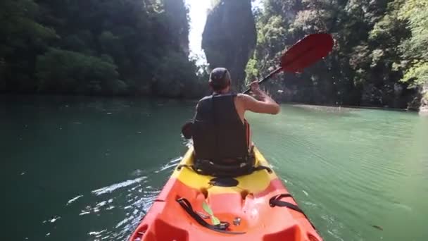 Oude man paddels op kajak in canyon — Stockvideo