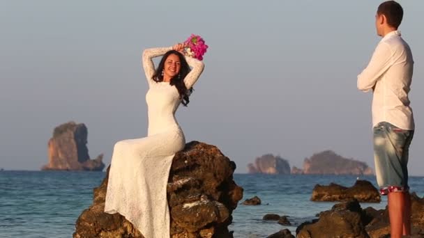 Sposa si siede sulla roccia all'alba — Video Stock