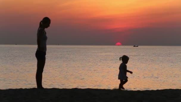 Dotter springer iväg från mamma på stranden — Stockvideo