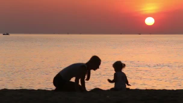 Mutter und Kleinkind bauen Burg am Strand — Stockvideo