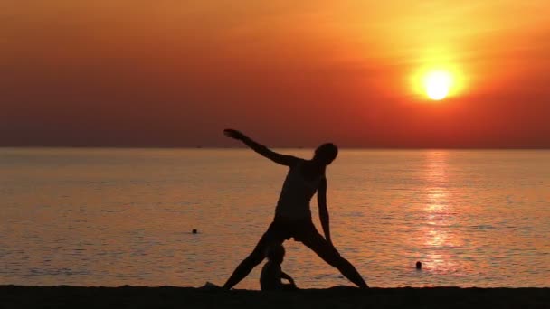 Matka robi ćwiczenia na plaży — Wideo stockowe