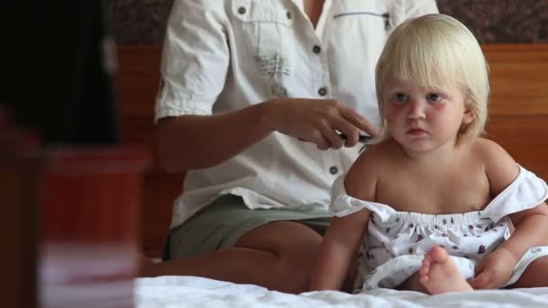 Мать чистит маленькую блондинку дочь — стоковое видео