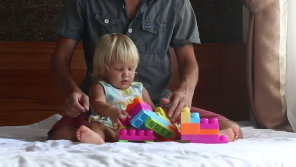 Dochter speelt speelgoed constructor met vader — Stockvideo