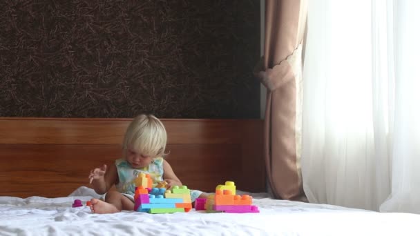 Маленькая девочка играет с конструктором игрушек — стоковое видео