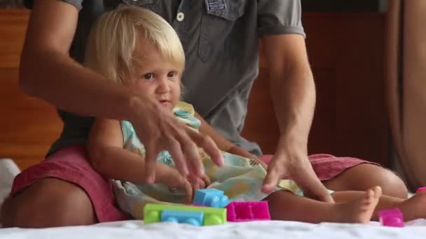 Küçük kızı babasının dizlerinin üstüne oturuyor — Stok video