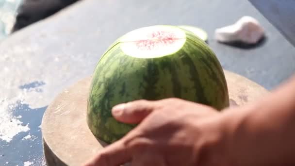 Mann schneidet Wassermelone mit Messer — Stockvideo