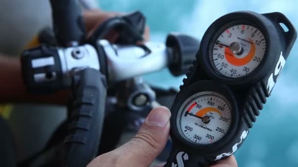 Инструктор включает стопкок акваланга и проверяет давление — стоковое видео