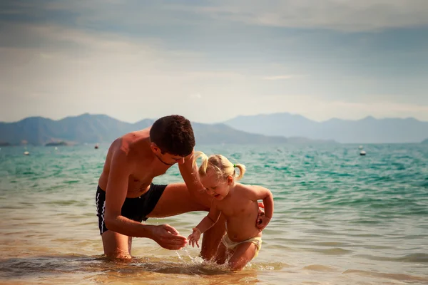 Vader en dochter op zand strand — Stockfoto