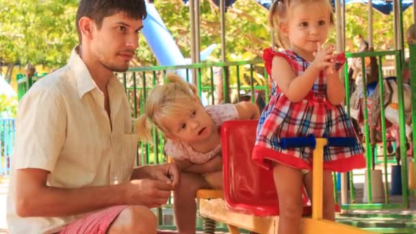 Father feeds little girls on  swing — Stock Video
