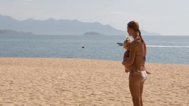 jeune mère et fille sur la plage 