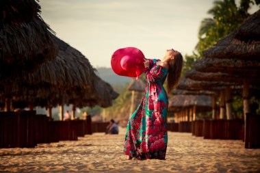 Sahilde büyük kırmızı şapkalı ince kız